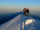 Rope team at sunrise arrives on the summit of Mont Blanc